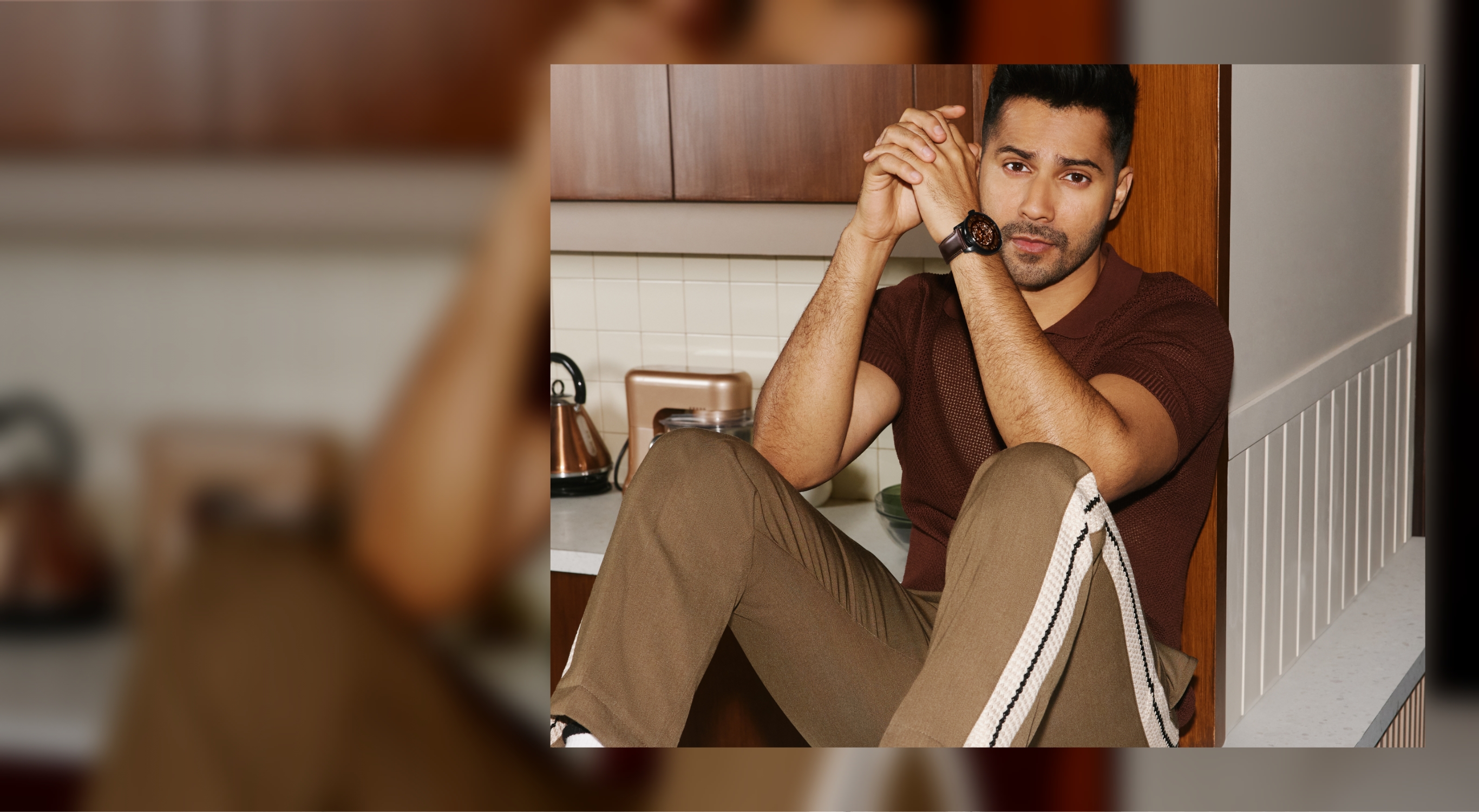 A man sitting on a kitchen counter and wearing the brown leather Townsman Automatic watch.